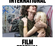 PLAKÁT K 59 MFF KARLOVY VARY STOJÍ NA FOTKÁCH, UKAZUJE OBJÍMÁNÍ